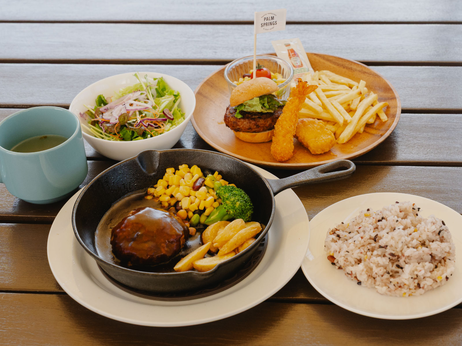 PALMバーグ・150g 1,100円（税込・ライス、サラダ、スープバー付き）と、キッズハンバーガープレート770円（税込）