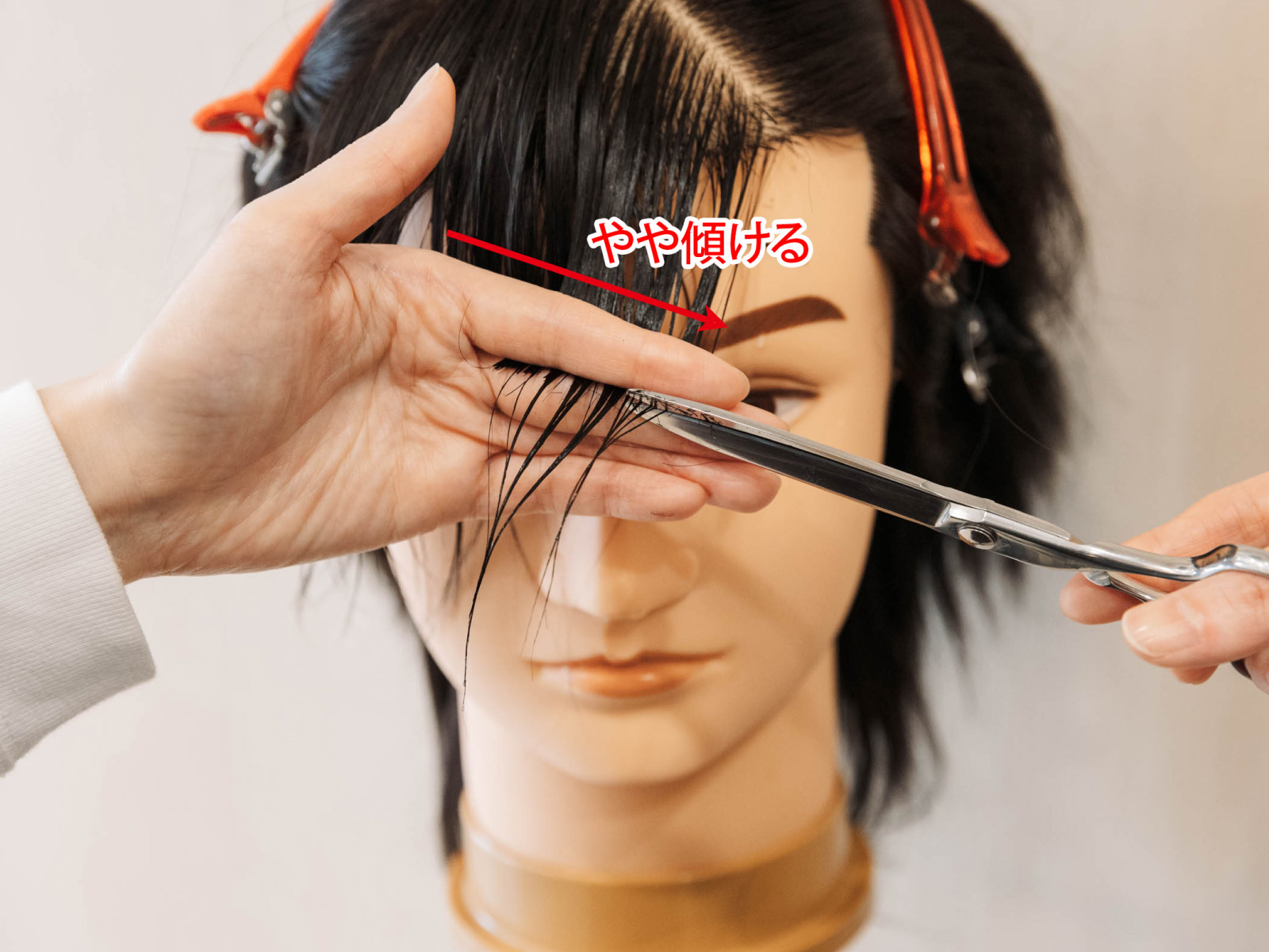 髪を挟む指を少しだけ傾けて切ります3